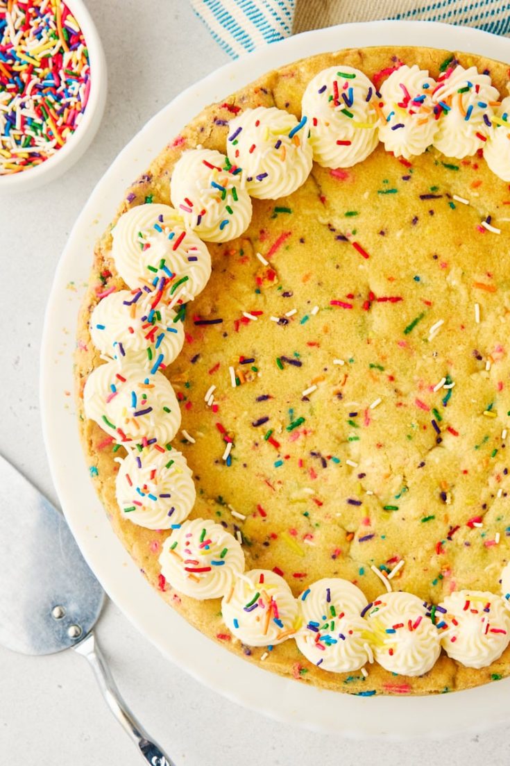 overhead view of sugar cookie cake on a white cake stand