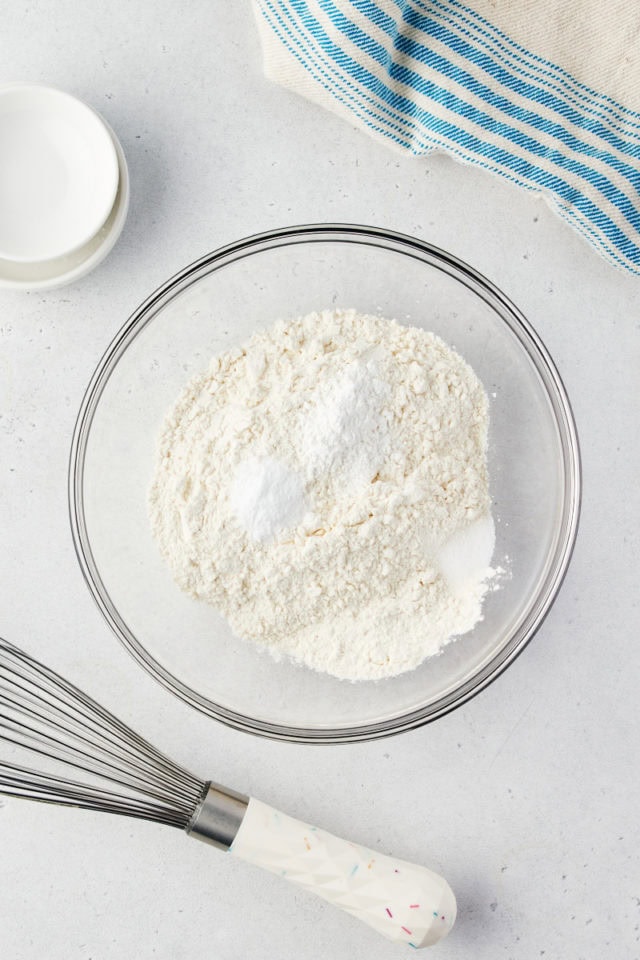 overhead view of flour, cornstarch, baking soda, and salt in a glass mixing bowl