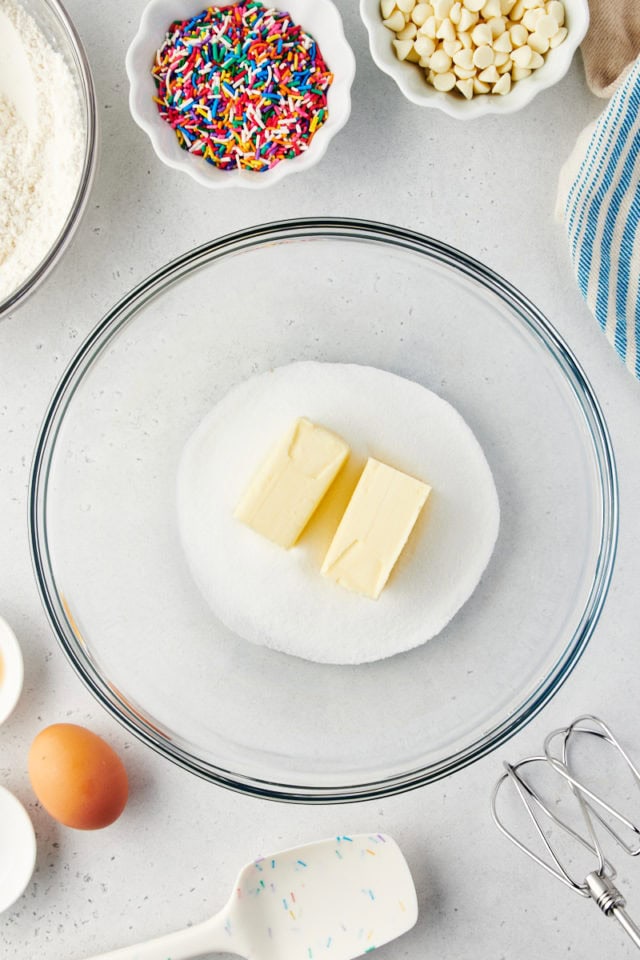 overhead view of butter and sugar in a glass mixing bowl