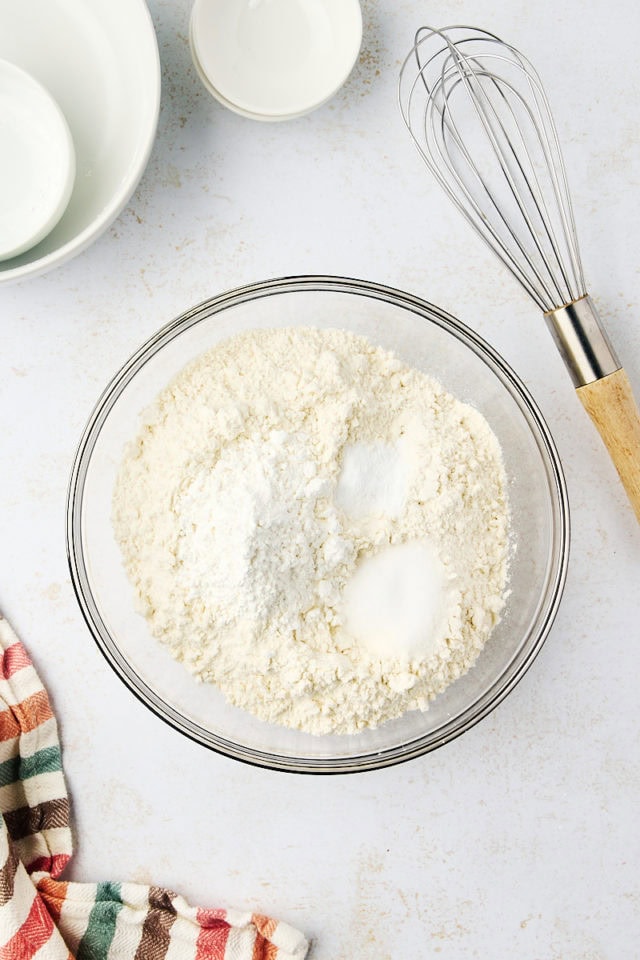 overhead view of flour, cornstarch, baking soda, and salt in a glass mixing bowl