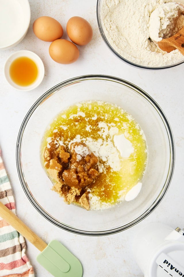 overhead view of melted butter, brown sugar, and sugar in a glass mixing bowl