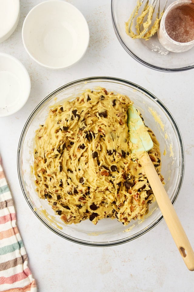 overhead view of mixed thick chocolate chip cookie dough in a glass bowl