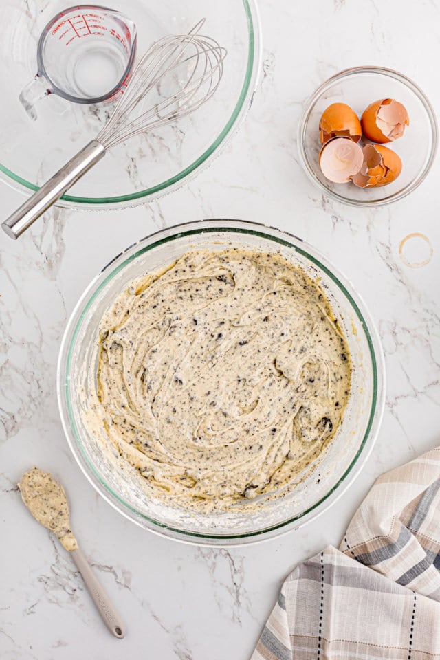 overhead view of cookies and cream cake batter in a glass mixing bowl