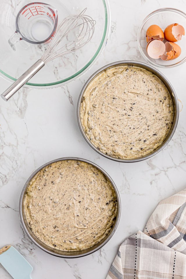 overhead view of cookies and cream cake batter in two round cake pans