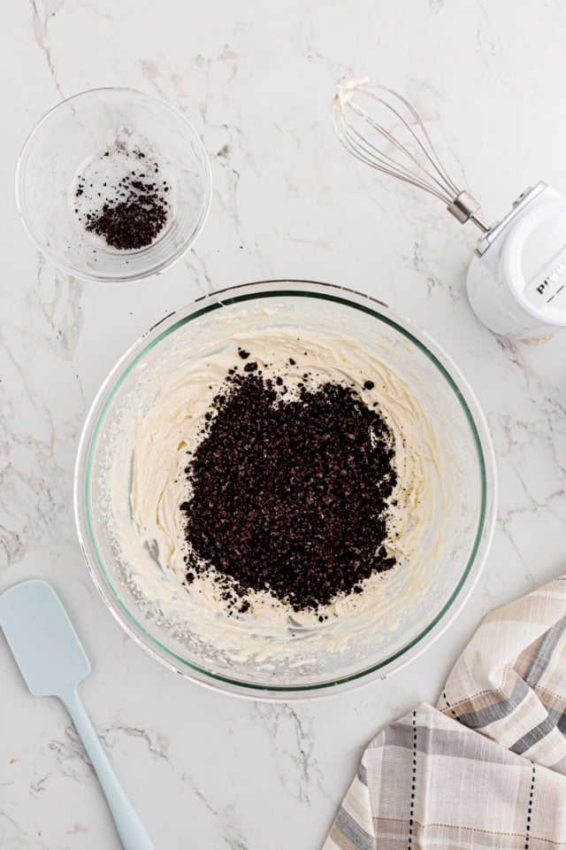 overhead view of cookie crumbs added to filling for cookies and cream cake