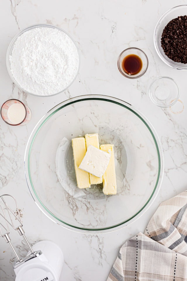 overhead view of butter and cream cheese in a glass mixing bowl