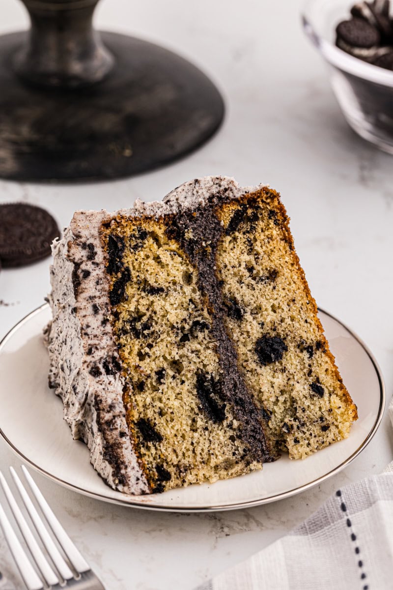 a slice of cookies and cream cake on a white plate