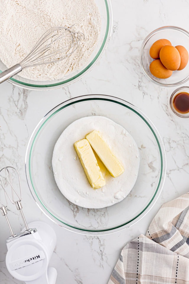 overhead view of butter and sugar in a glass mixing bowl