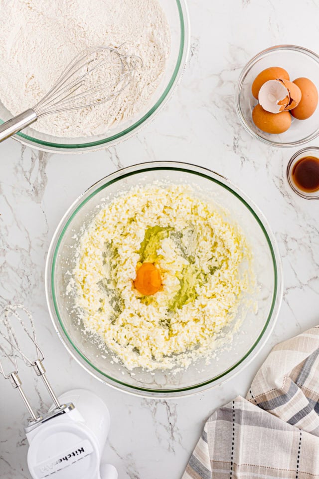 overhead view of egg added to creamed butter and sugar