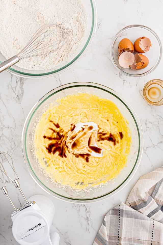 overhead view of sour cream and vanilla extract added to cake batter