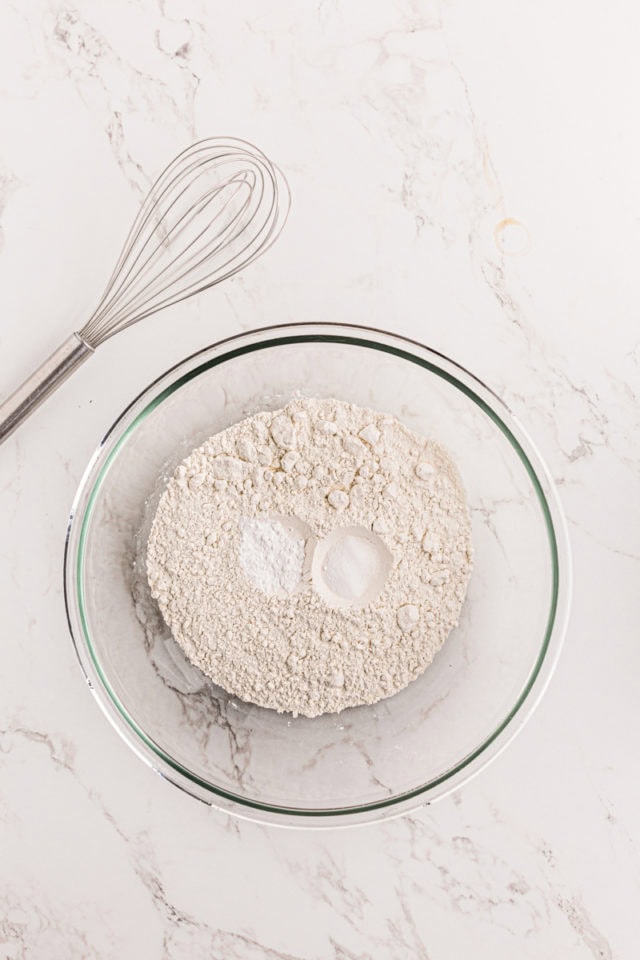 overhead view of flour, baking powder, and salt in a glass mixing bowl