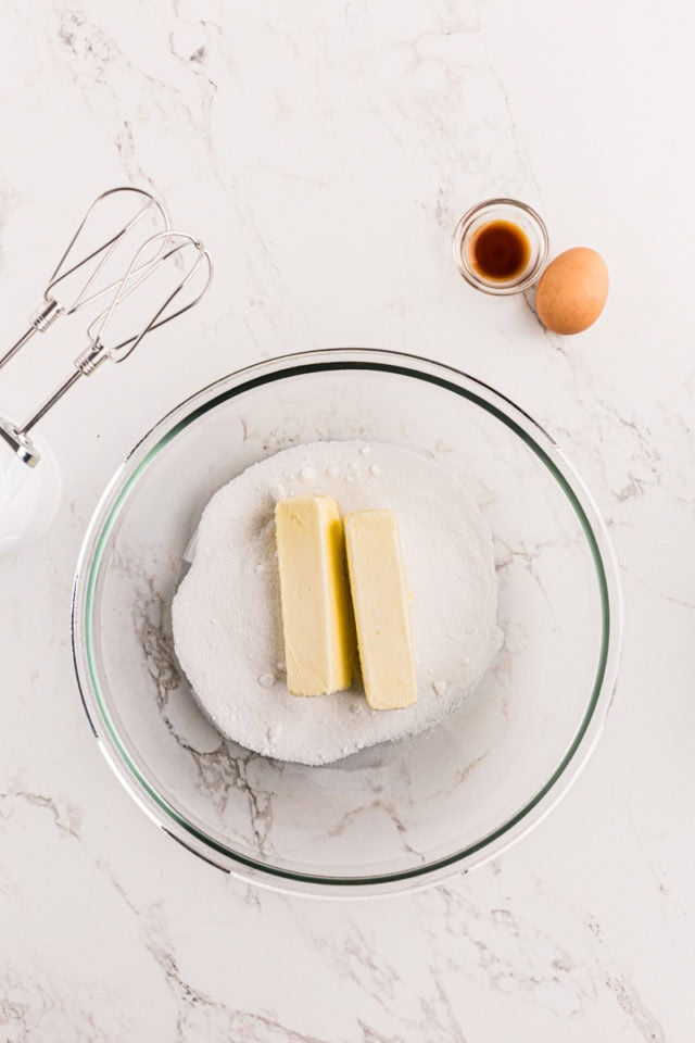 overhead view of butter and sugar in a glass mixing bowl