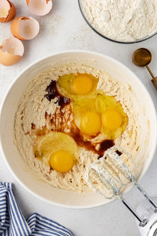 overhead view of eggs and vanilla extract added to creamed butter and sugar