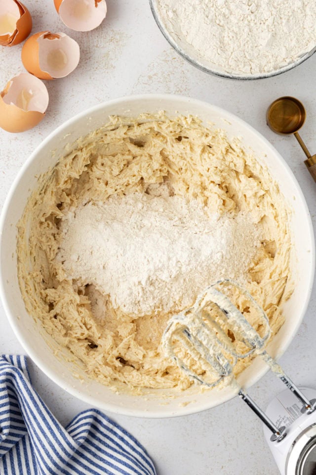 overhead view of dry ingredients added to wet ingredients for cookie dough