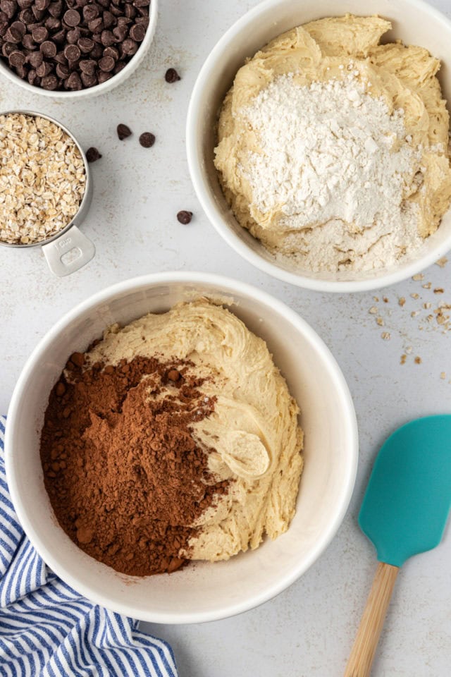 overhead view of cocoa powder and flour added to two bowls of cookie dough