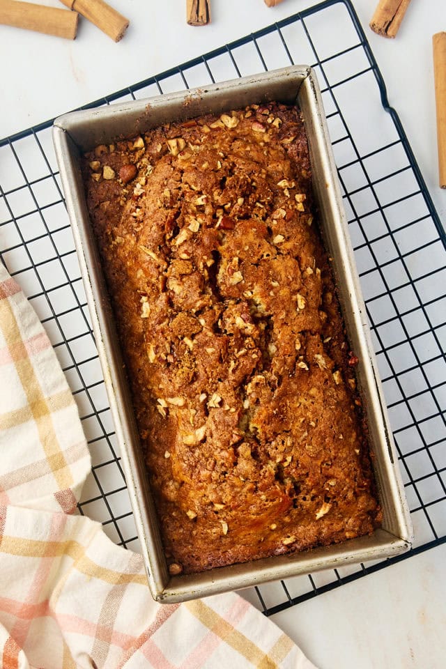 overhead view of freshly baked cinnamon swirl bread in a loaf pan on a wire rack