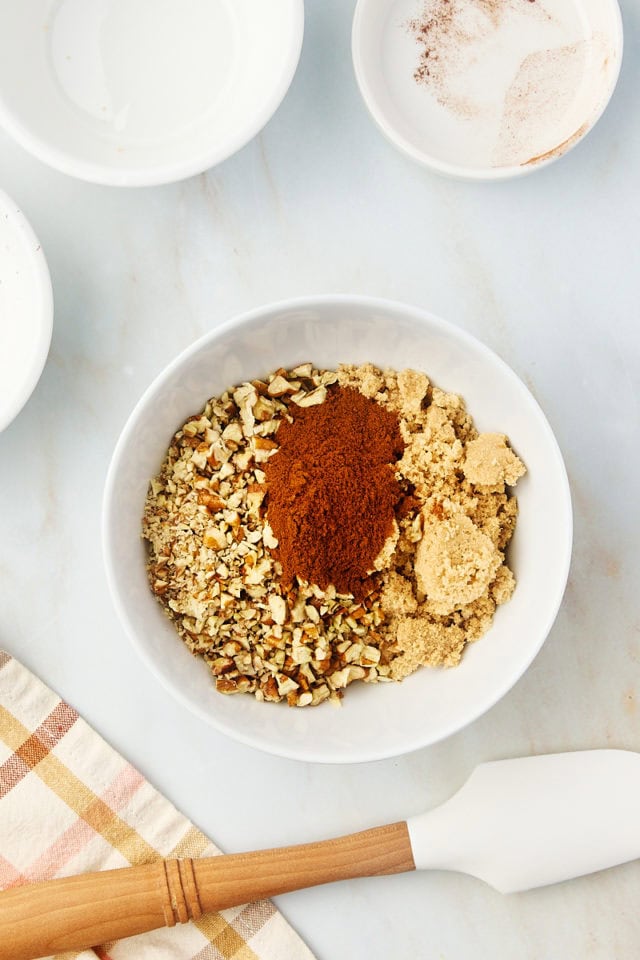 overhead view of brown sugar, nuts, and cinnamon in a white bowl