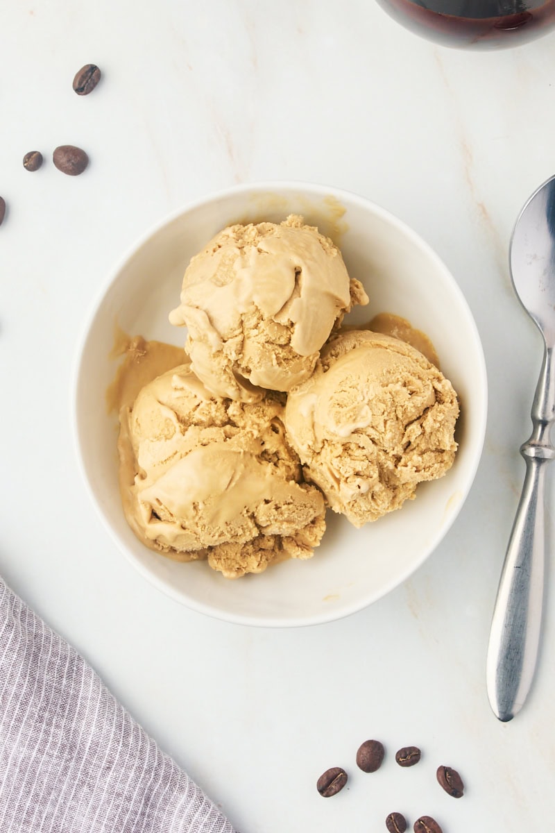 overhead view of three scoops of coffee ice cream in a white bowl