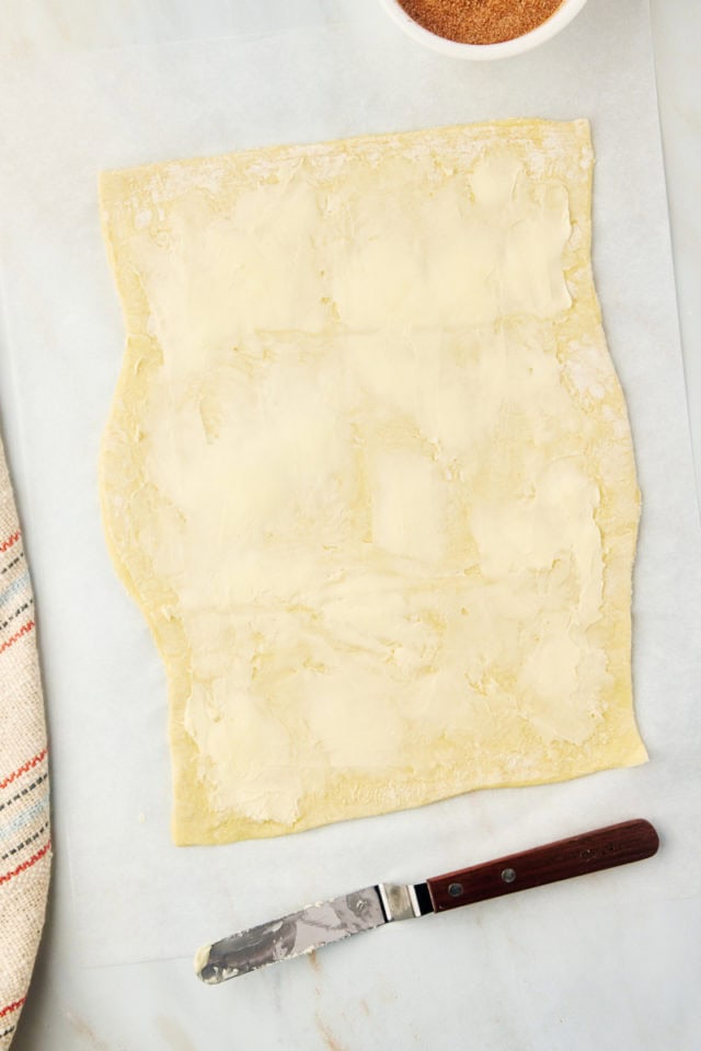 overhead view of butter spread on puff pastry