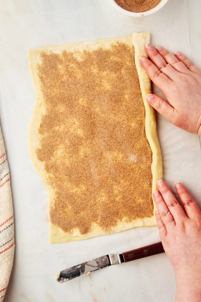 overhead view of cruffin dough being rolled into a log