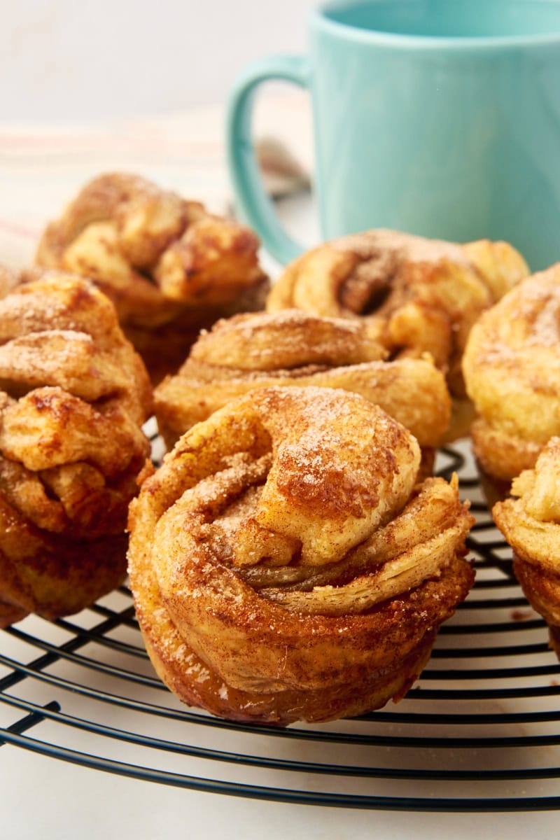 cruffins on a wire cooling rack with a blue coffee mug in the background