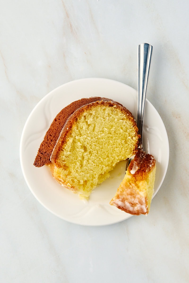 Overhead view of limoncello cake slice on plate with bite on fork