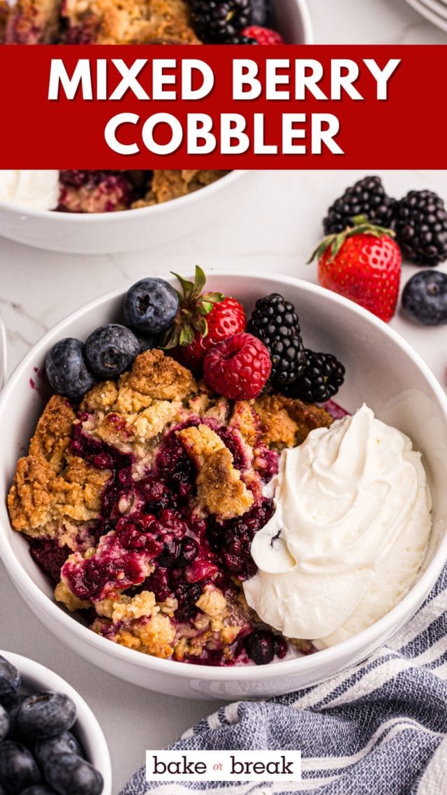 mixed berry cobbler in a white bowl with fresh berries and whipped cream; text overlay "mixed berry cobbler bake or break"