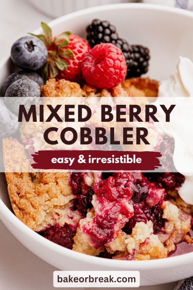 mixed berry cobbler in a white bowl with fresh berries and whipped cream; text overlay "mixed berry cobbler easy & irresistible bakeorbreak.com"