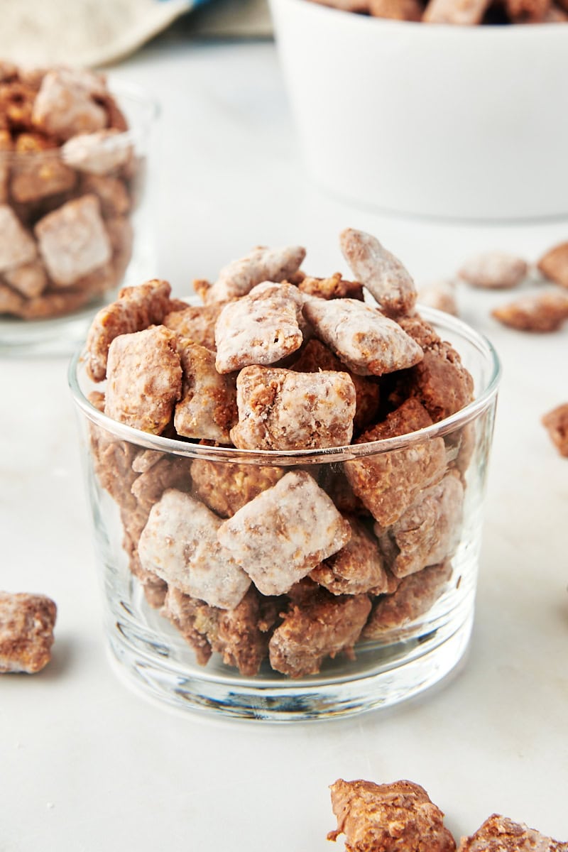 muddy buddies in a small glass with more muddy buddies in the background