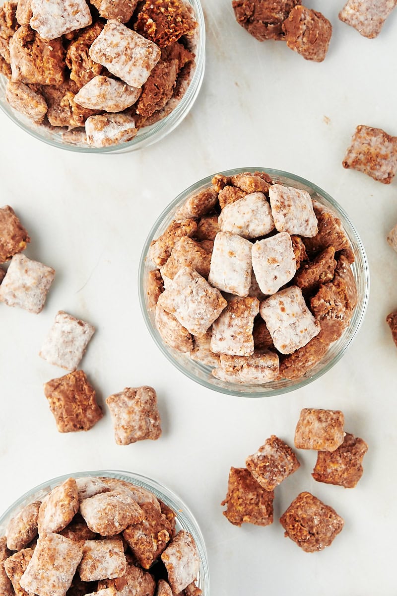 overhead view of muddy buddies in small glasses with more muddy buddies scattered around them