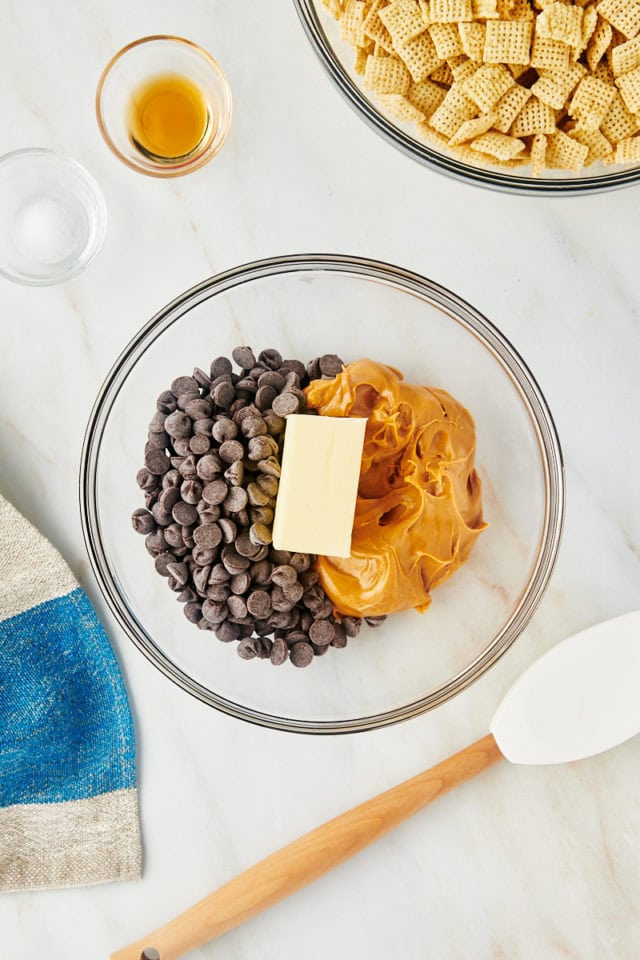 overhead view of chocolate chips, peanut butter, and butter in a glass mixing bowl