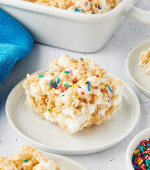 a rice crispy treat on a white plate with more treats surrounding