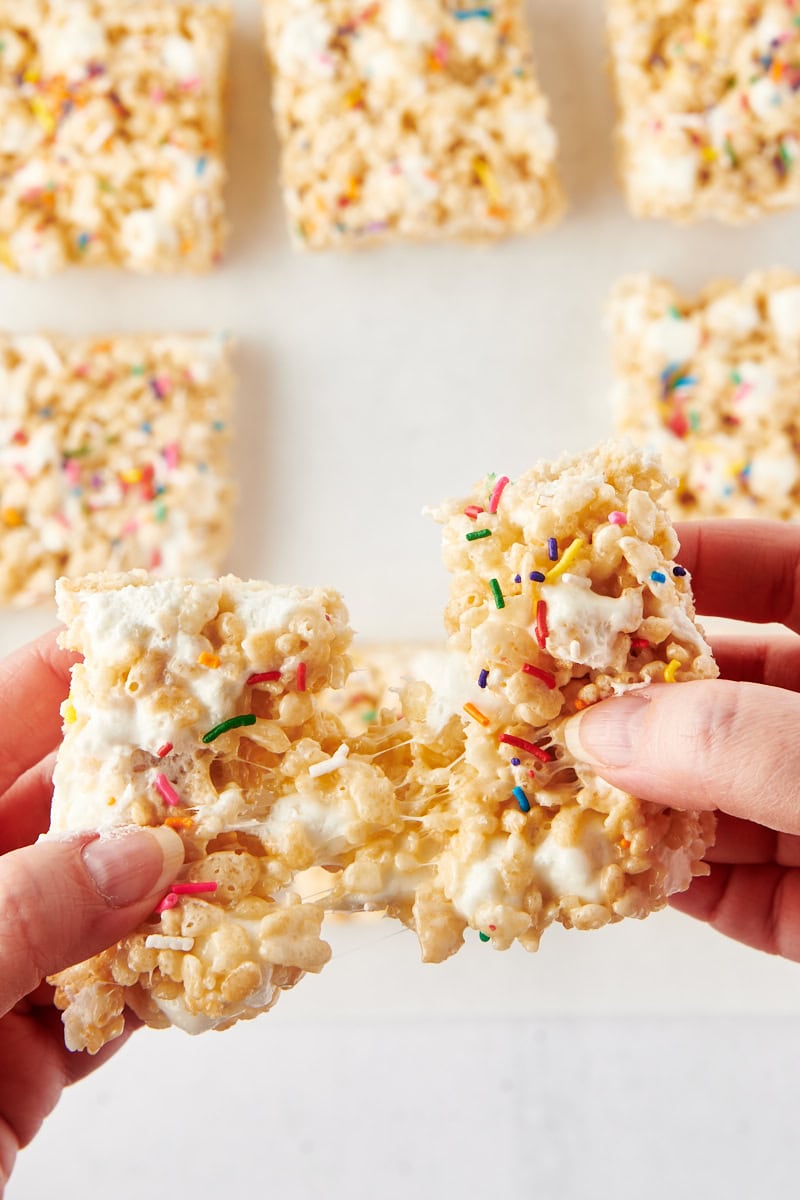 a rice crispy treats being pulled apart to show the gooey marshmallow filling