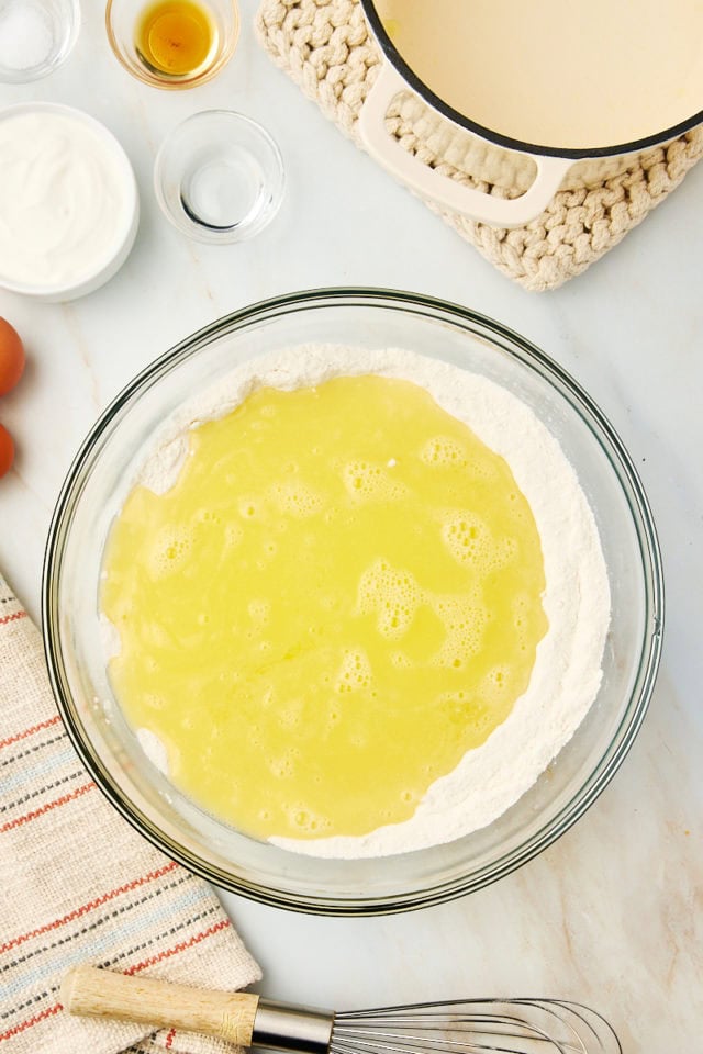 overhead view of melted butter added to flour and sugar in a mixing bowl