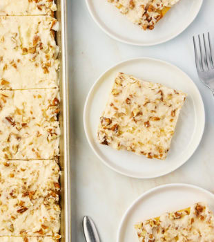overhead view of slices of white Texas sheet cake on white plates and a baking sheet
