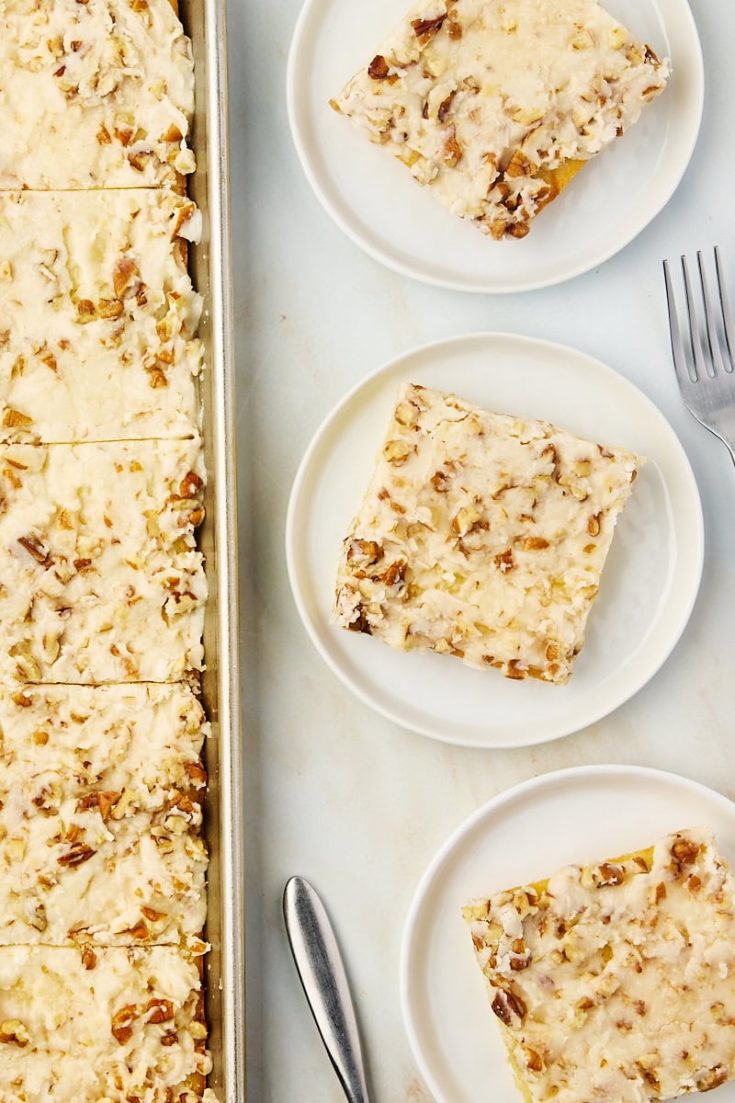 overhead view of slices of white Texas sheet cake on white plates and a baking sheet