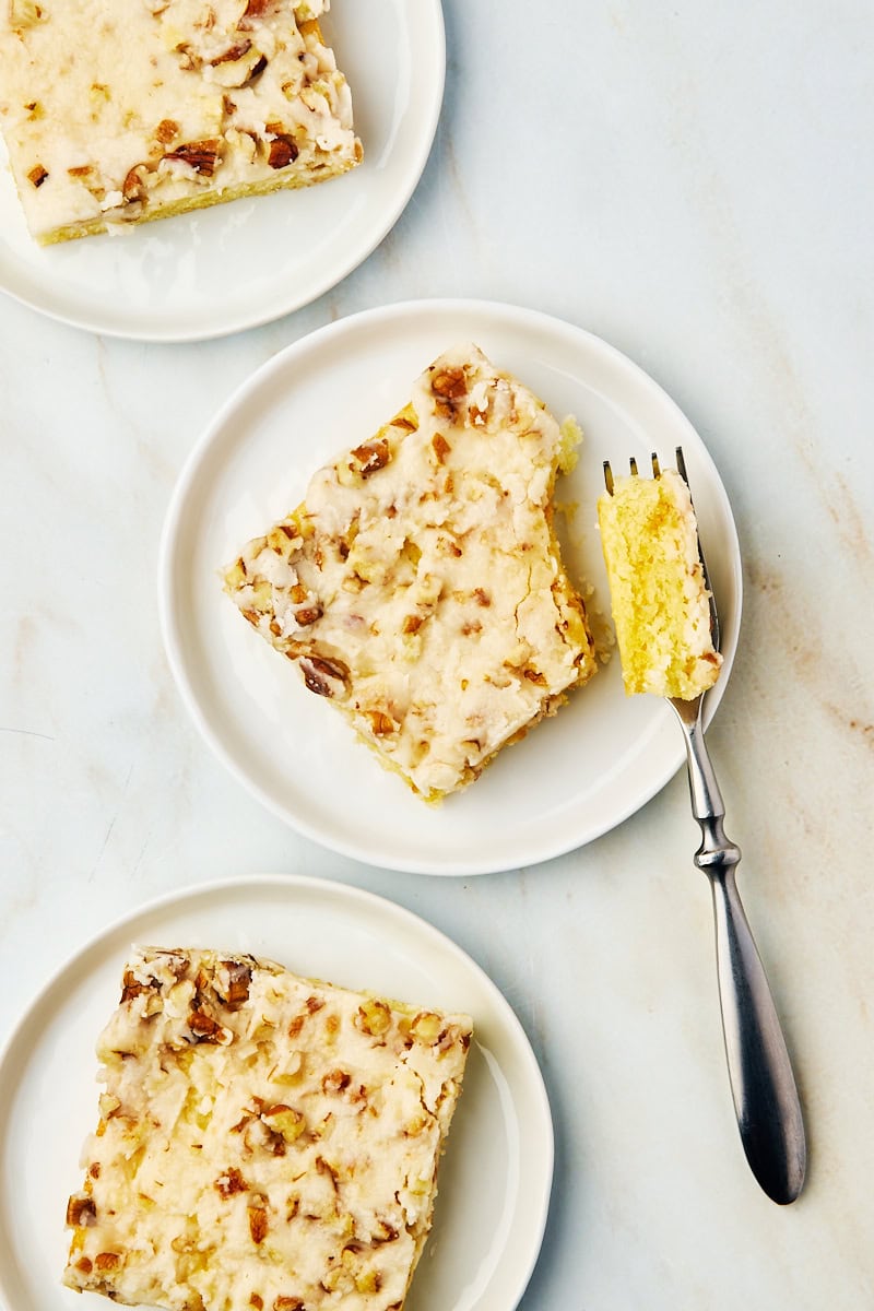 overhead view of three slices of white Texas sheet cake on white plates