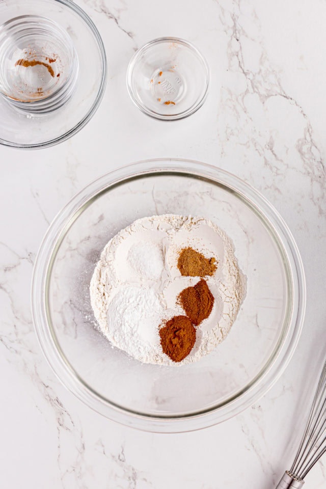 overhead view of flour, spices, and salt in a glass mixing bowl