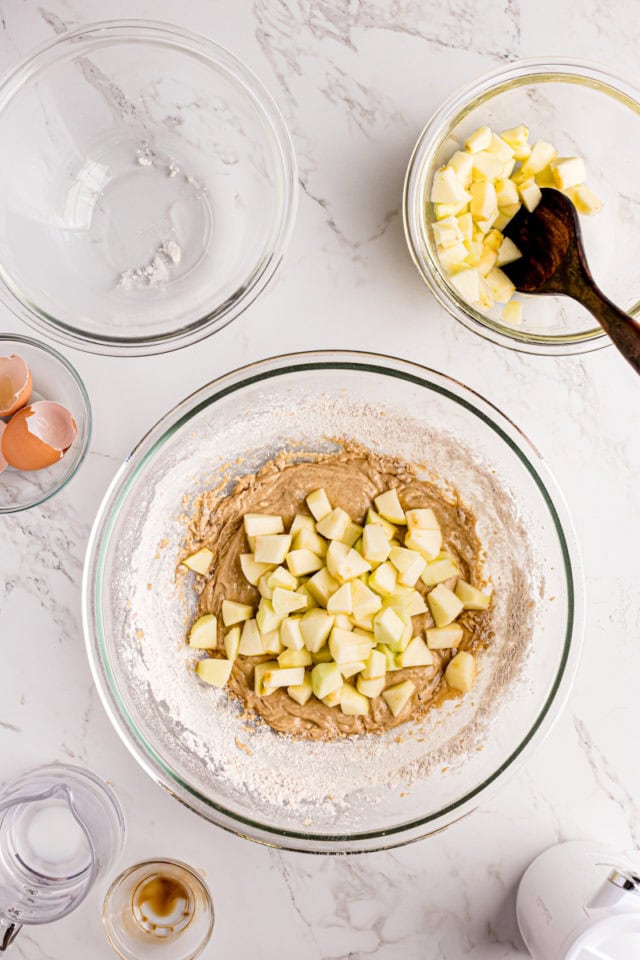 overhead view of diced apples added to apple fritters batter