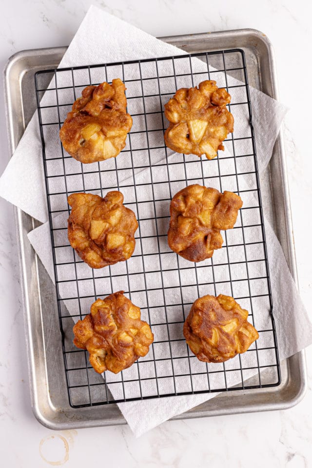 overhead view of apple fritters on a wire rack