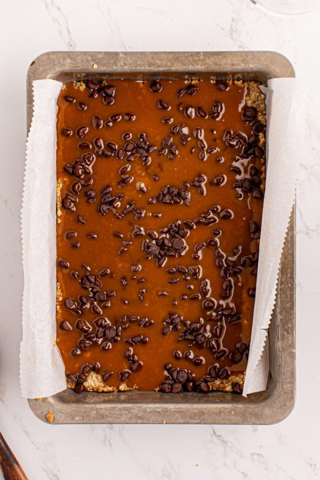 overhead view of caramel layer added to caramel oatmeal bars crust