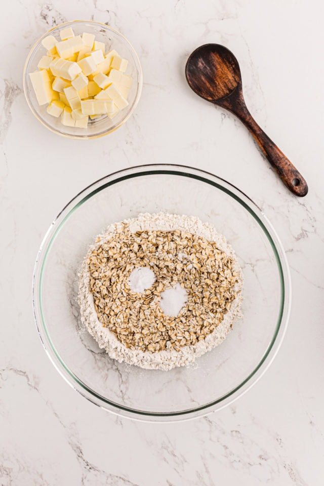 overhead view of oats, flour, brown sugar, baking powder, and salt in a glass mixing bowl