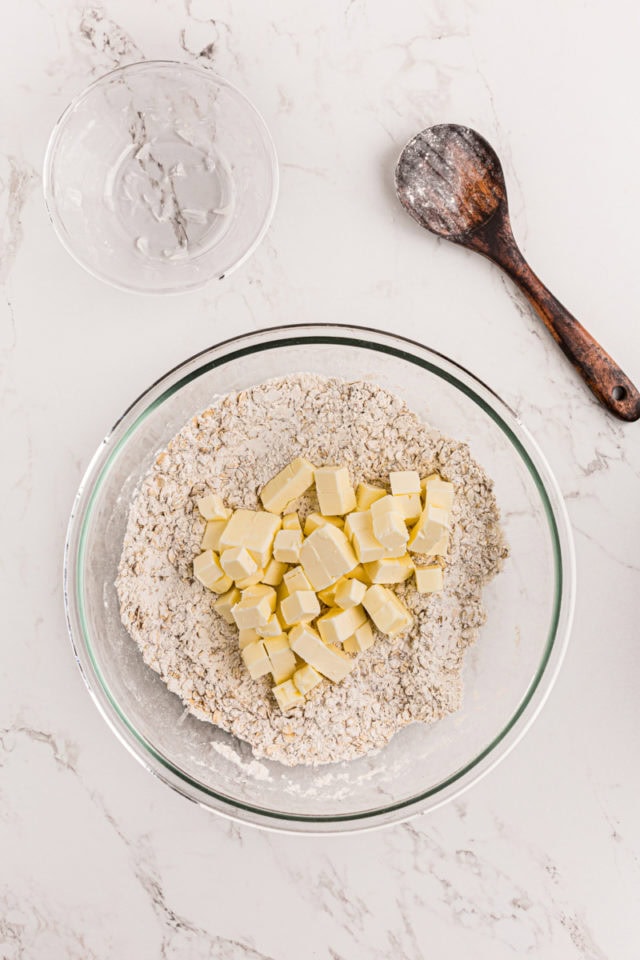 overhead view of butter added to crust mixture for caramel oatmeal bars