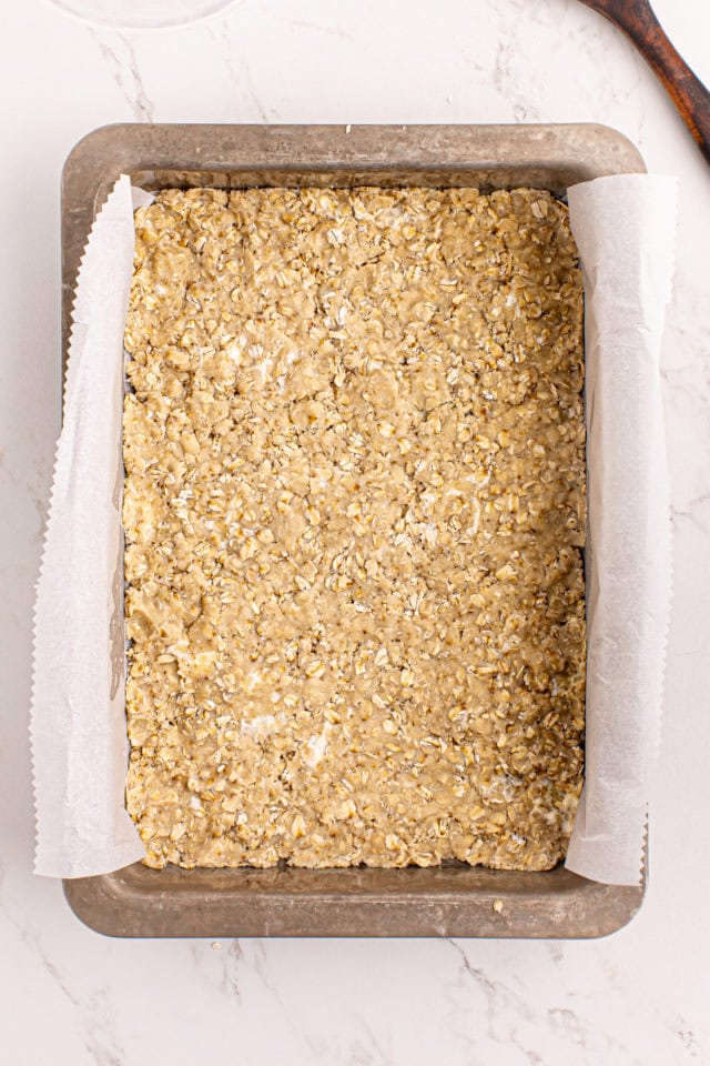 overhead view of caramel oatmeal bars crust in a baking pan ready to go into the oven