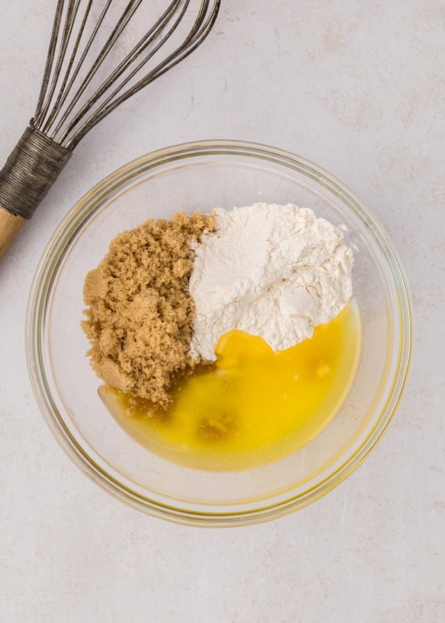 overhead view of melted butter, brown sugar, flour, and cinnamon in a glass mixing bowl