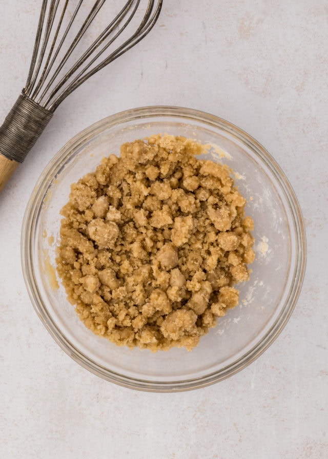 overhead view of mixed streusel in a glass mixing bowl