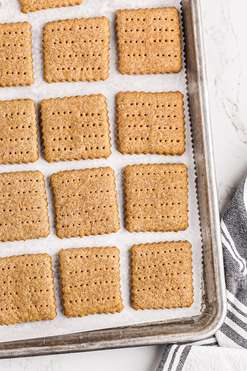 overhead view of freshly baked graham crackers on a parchment-lined baking sheet