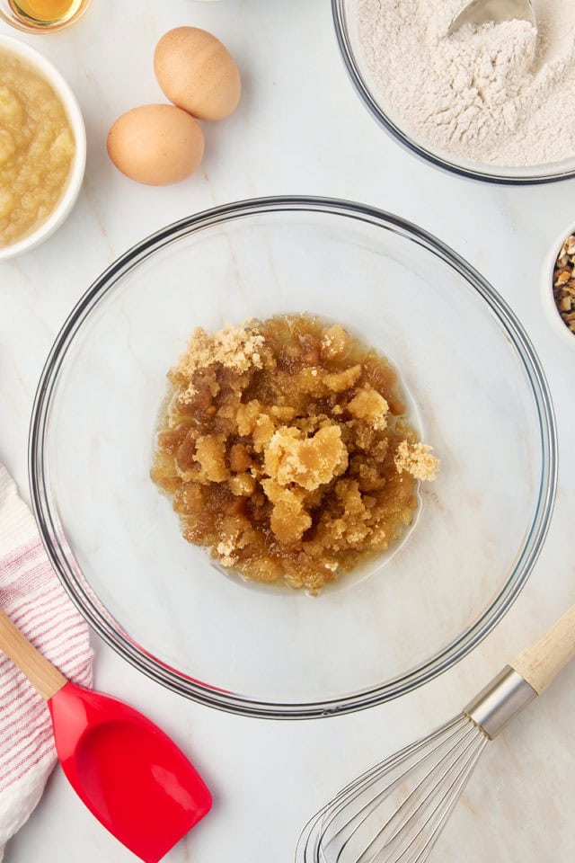 overhead view of brown sugar and oil in a glass mixing bowl