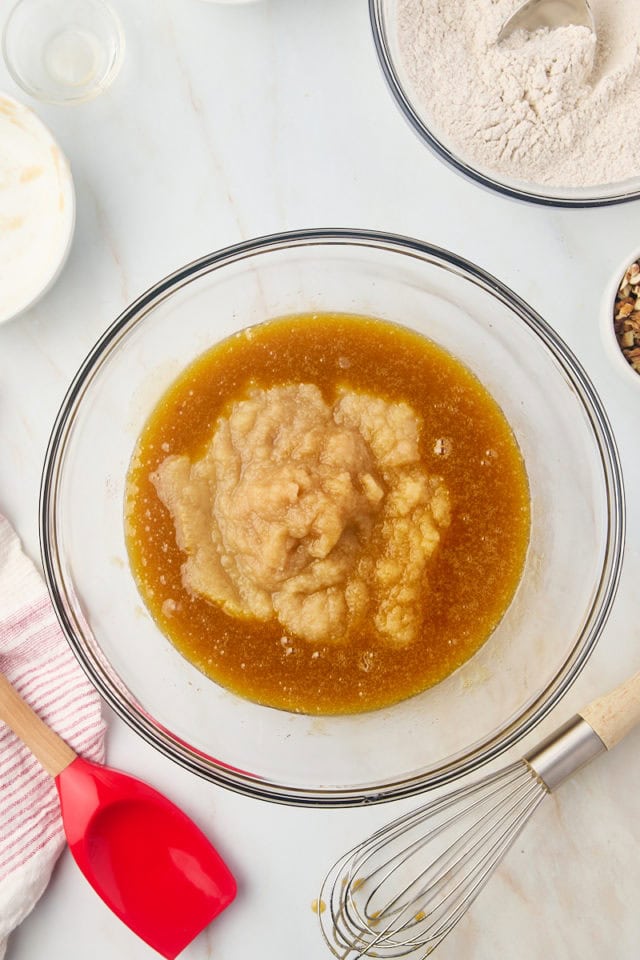 overhead view of applesauce and vanilla extract added to applesauce cake batter