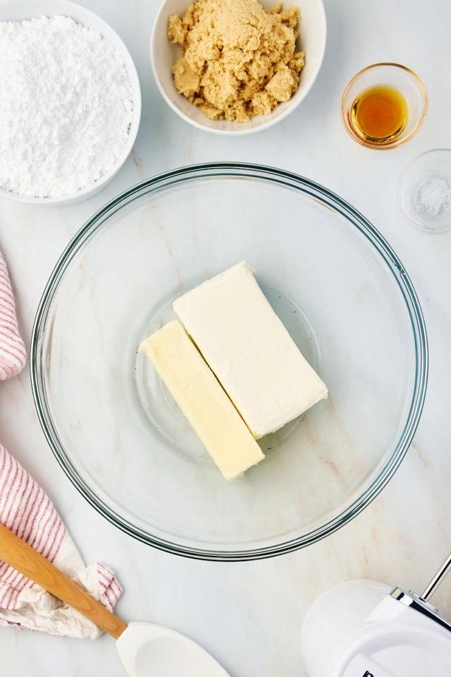 overhead view of butter and cream cheese in a glass mixing bowl